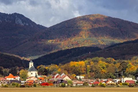 Sunlight Hitting Autumn Forest Hillside Over Small Town Fotos Stock