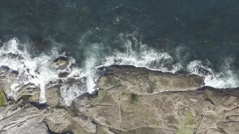 Sunlight hitting breaking waves on rocky coastline Video stock 145830611
