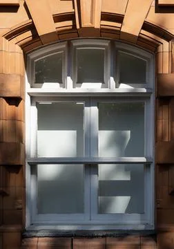Sunlight illuminates the clean lines of a multi-paned wooden window, housed.. Stock Photos