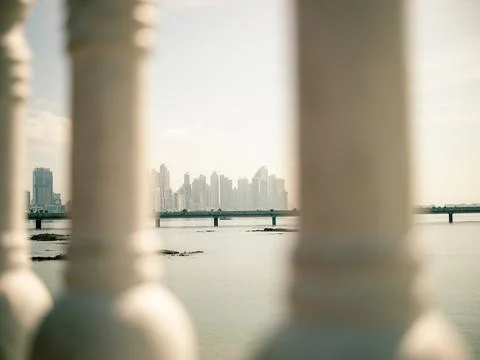 Sunlight illuminates the distant cityscape over calm water Stock-Fotos