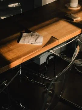 Sunlight illuminates a folded cloth tissue resting on a modern wooden table Stock Photos