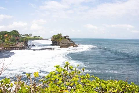 Sunlight illuminates powerful waves rolling onto the black sand beaches of Stock Photos