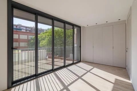 Sunlight illuminates the room, creating shadows on the floor. New room in a 스톡 사진
