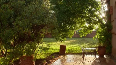 Sunlight Illuminates Villa Patio and Garden with Metal Chairs in Marrakesh Stock Footage 342680840