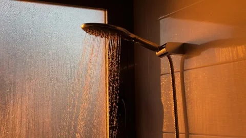 Sunlight illuminating modern shower with water droplets falling against window Stock Footage 295205632