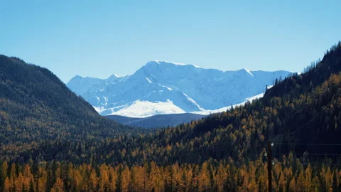 Sunlight illuminating snow capped mountain range Video stock 292229357