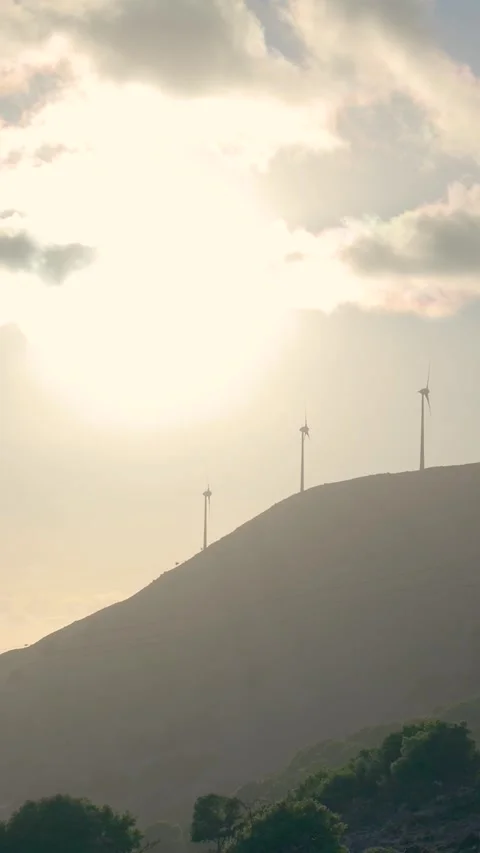 Sunlight illuminating wind turbines on top of a hill Stock-Footage 294963772