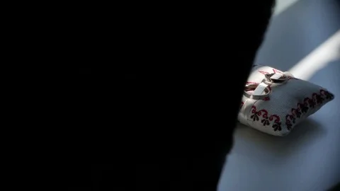 Sunlight lines on wedding rings on a pillow Stock Footage