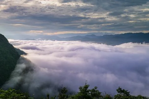 The sunlight makes the sea of clouds change unpredictably, like stormy waves. Stock Photos