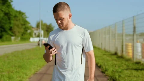 At sunlight man runner stopped checks mail use phone read good news and running Stock Footage 140365853