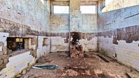 Sunlight moving through the empty windows of an old, abandoned, and decaying Stock Footage 341457344