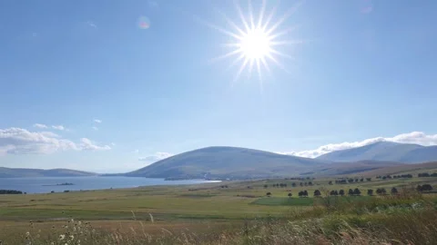 Sunlight over fields and water in a picturesque landscape Vídeo Stock 333784852