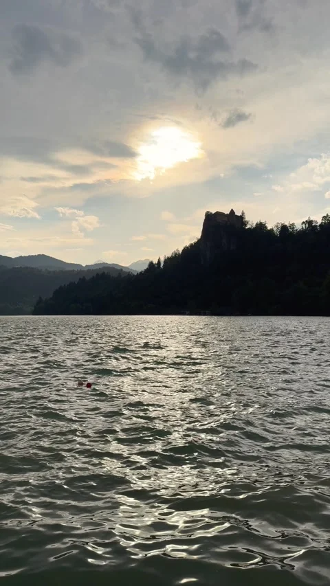 Sunlight over Lake Bled with dramatic clouds and water reflection in Slovenia. T Stock Footage 339012450