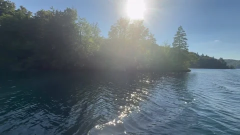 Sunlight over Plitvice Lakes water with forest and sparkling reflections. The vi Stock Footage 337534470