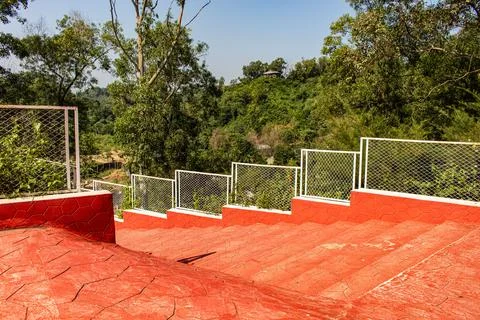 Sunlight Over Red Steps and Green Hill Trees in Chattogram Stock Photos