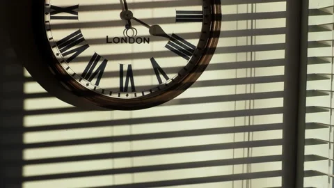 Sunlight patterns on a wall with a clock. Stock Footage 240022864