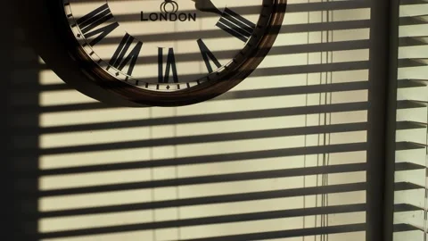 Sunlight patterns on a wall with a clock. Stock Footage 240022888
