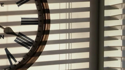 Sunlight patterns on a wall with a clock. Stock Footage 240022940