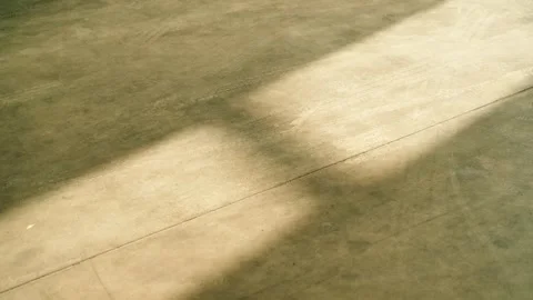 Sunlight Patterns on Workshop Floor with Tire Marks Stock Footage 333693262