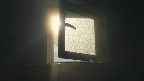 Sunlight penetrates through an bathroom open window  casting relaxing warm am Stock Footage 326003437