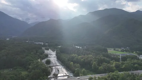 Sunlight pierces cloud cover over mountainous valley Видео 339112489