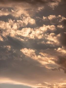 Sunlight pierces through textured clouds during golden hour 写真素材