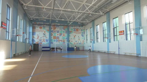 Sunlight pours through wide windows filling bright gymnasium Stock Footage 310244961