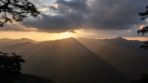 Sunlight Rays Breaking Over Mountain Peaks During Golden Hour Panoramic Shot Stock Photos