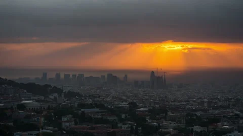 Sunlight rays over Barcelona city skyline. Sunrise over the horizon 库存影片 131379086
