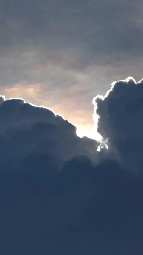 Sunlight rays piercing through dark storm clouds at sunset, cinematic sky d.. Vidéo 345198437