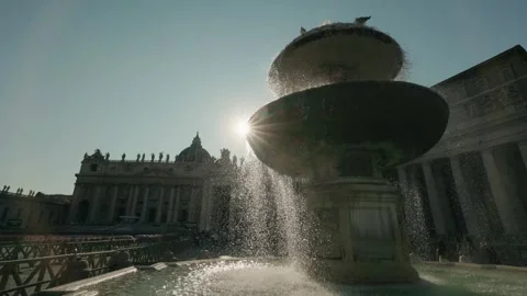 Sunlight rays shine through fountain water droplets on saint peters square .. Vidéo 334835160