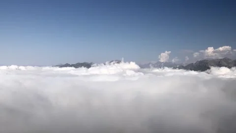 Sunlight reaches distant mountain peaks while white clouds - Elevated Landscape Vidéo 339644160