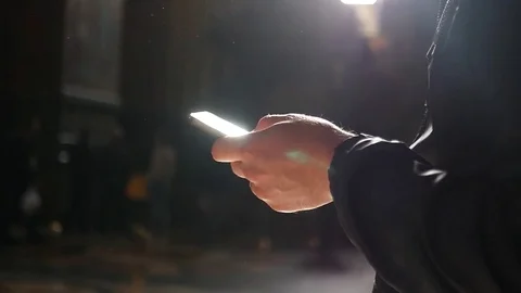 Sunlight is reflected and flashes in the phone in the hands of a man. slow Stock Footage 78971238