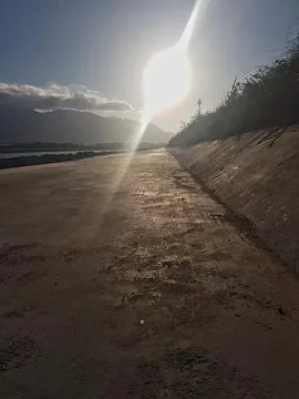 Sunlight is reflected off the ground as the sun envelops the long route in warm Stock Photos