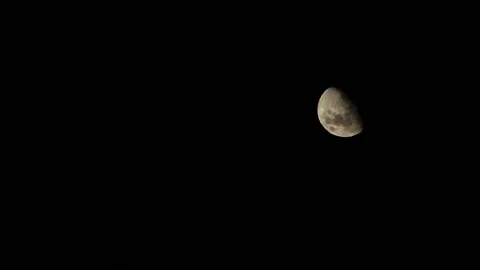 Sunlight reflected in rising moon on black night sky Stock Footage 181755179