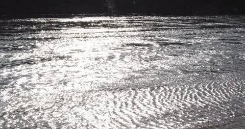 Sunlight reflected on surface of fast flowing river in spring Stock Footage 127132133
