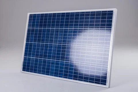 Sunlight reflecting on blue solar panel isolated against white background, copy Foto stock