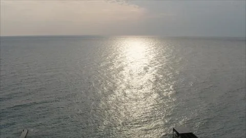 Sunlight reflecting on calm ocean surface at sunset Stock Photos