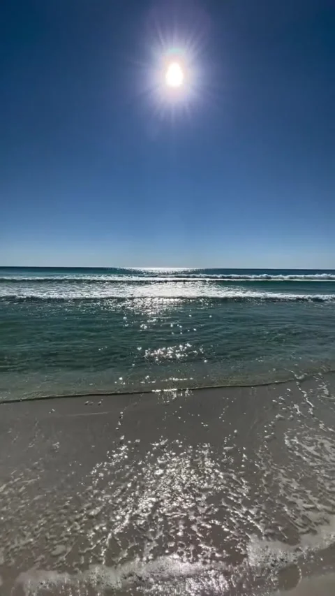 Sunlight reflecting on calm waves at a beautiful sandy beach Vídeos de archivo 334084903