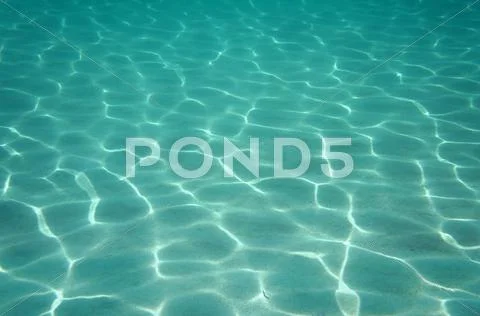 Sunlight reflecting on a sandy ocean floor Stock Photos