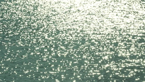 Sunlight reflecting off the surface of dark rippling water. Видео 331118225