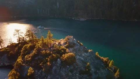 Sunlight reflection behind Fannette Island in Emerald Bay. A boat leaves a wake Stock Footage 346532541