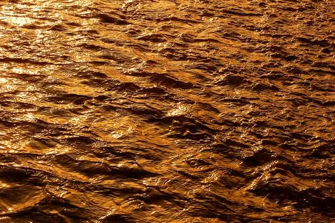Sunlight reflection ripple of river of water gold background Stock Photos