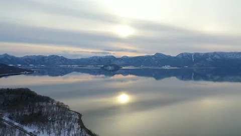 Sunlight reflection upon still waters of calm winter lake Stock Footage 155918217