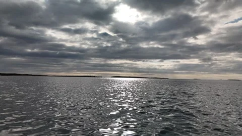 Sunlight reflection on water under dramatic cloudy sky Stock Footage 332680127
