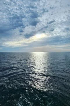 Sunlight Reflections on Open Sea Under Cloudy Sky Stock Photos