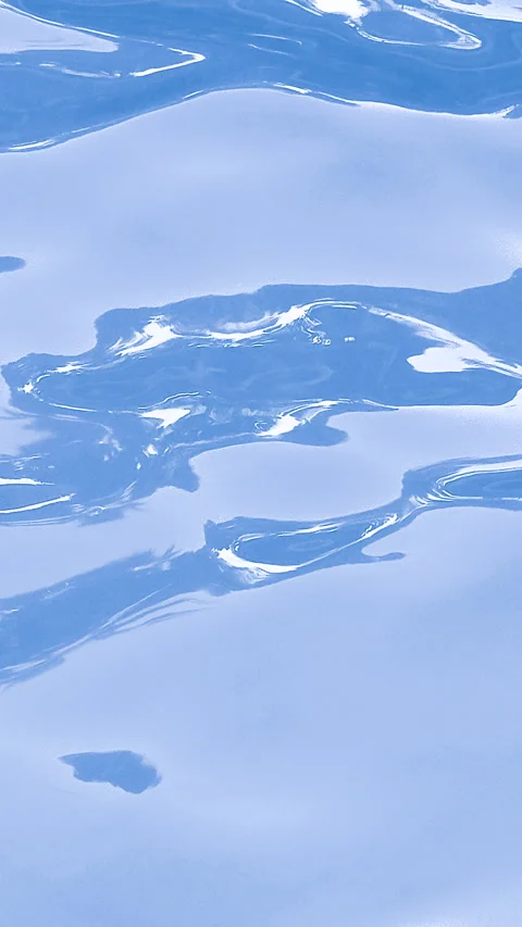 Sunlight reflections shimmer across a clear water surface with gentle ripples Stock Footage 346776281