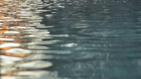 Sunlight reflections shimmer across moving water surface forming dynamic 库存影片 330344827