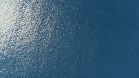 Sunlight reflects on calm ocean water surface on a sunny day outdoors Video stock 328047799