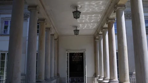 Sunlight reflects on ceiling of neoclassical colonnade with stone pillars hangin Stock Footage 312600357